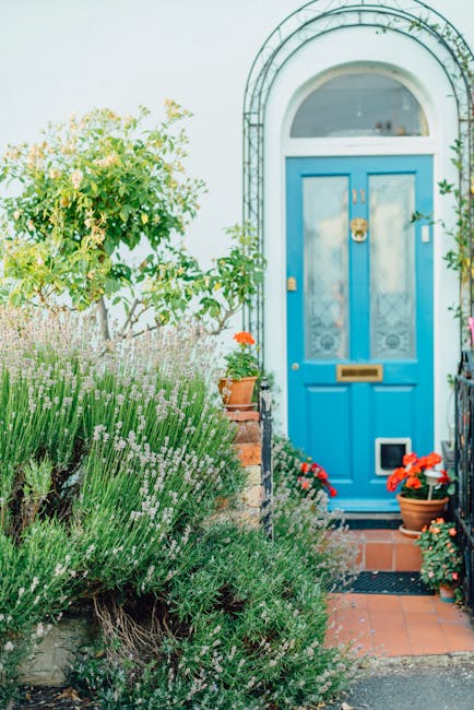 A close-up view of two small, green front doors numbered 31 and 33, set into a red brick wall of a residential building. The doors are framed by white trim and feature letterboxes, door knockers, and 